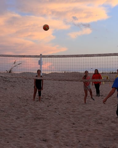 Beach volleyball at sunset on the Ocean Lakes oceanfront, sea oats and sand dunes in the background