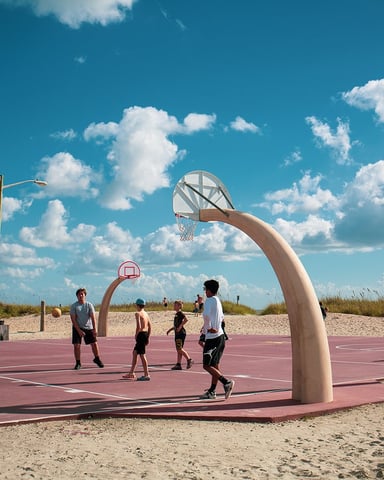 Kids playing basketball on the oceanfront court at Ocean Lakes with sand dunes and sea oats in the background
